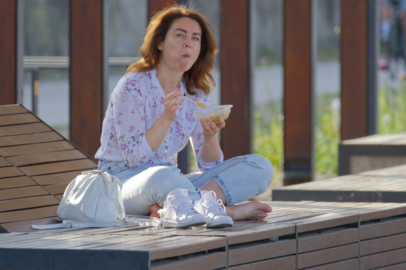 Young woman eating on the Vistula river bank